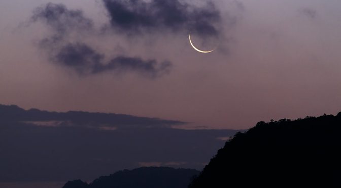 silhouette of mountain under the moon covered with clouds