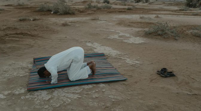photo of man bowing on mat during dawn