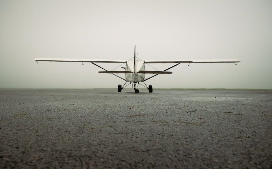 A solitary small aircraft captured on a foggy airport runway, showcasing aviation serenity.