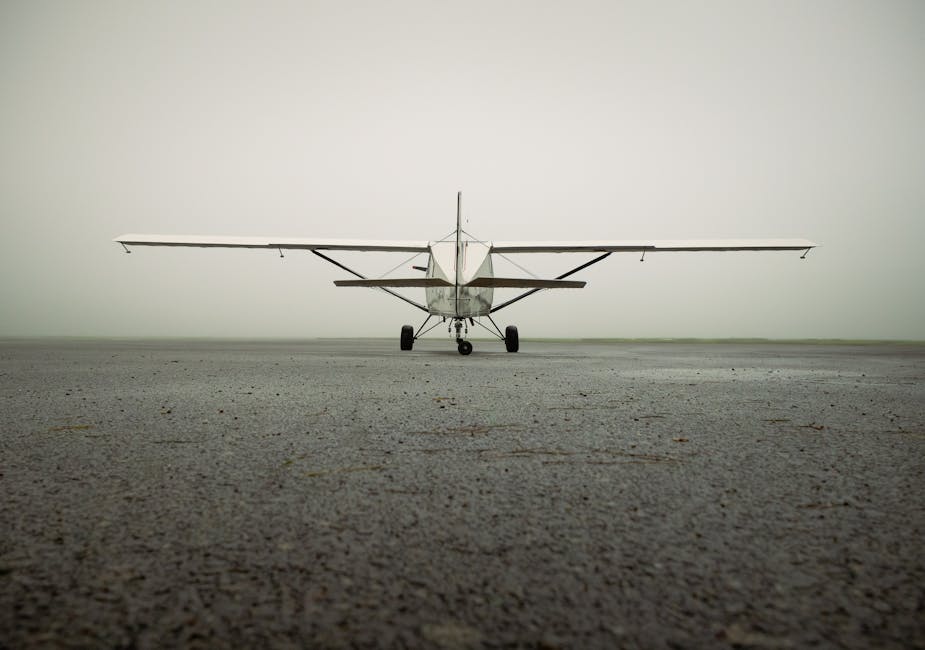 A solitary small aircraft captured on a foggy airport runway, showcasing aviation serenity.