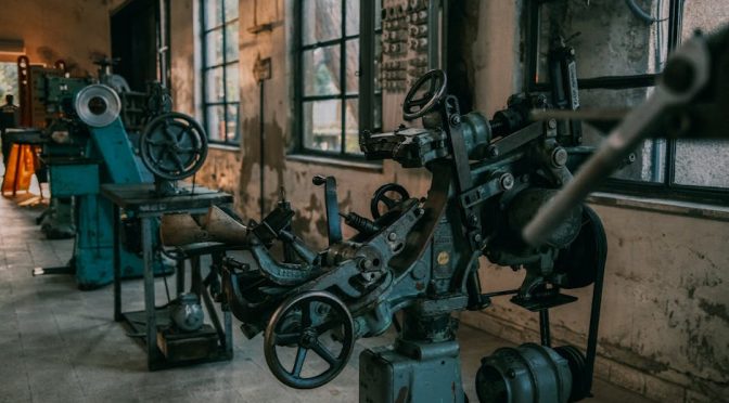 Old industrial machines in an abandoned workshop with vintage tools and equipment.