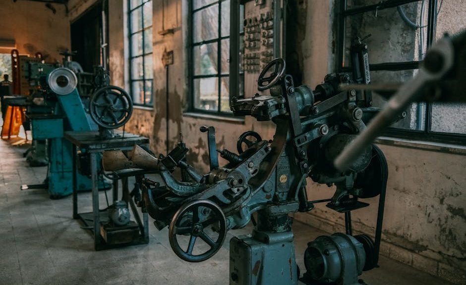 Old industrial machines in an abandoned workshop with vintage tools and equipment.