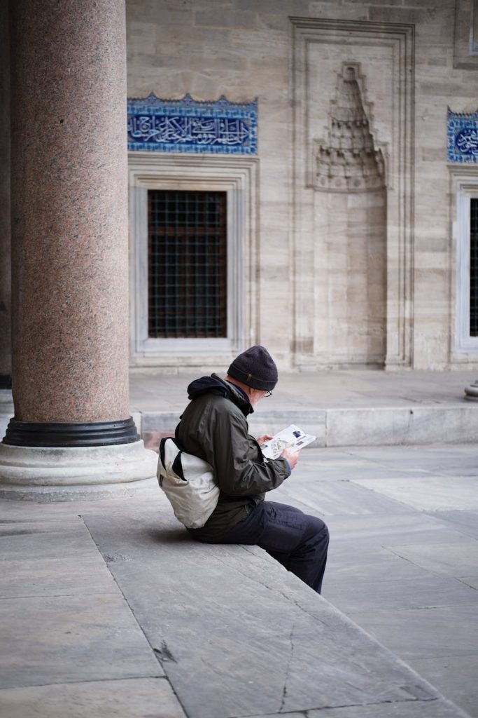 man sitting in front of a mosque