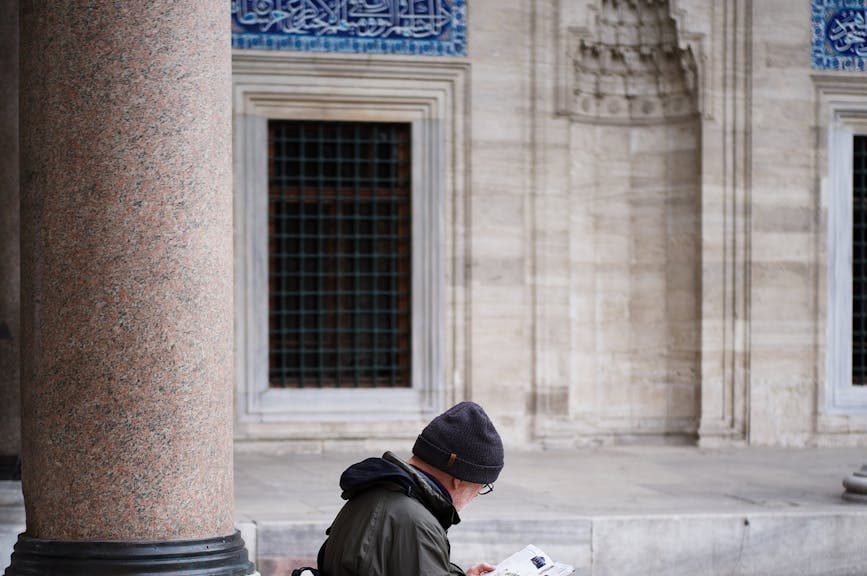 man sitting in front of a mosque