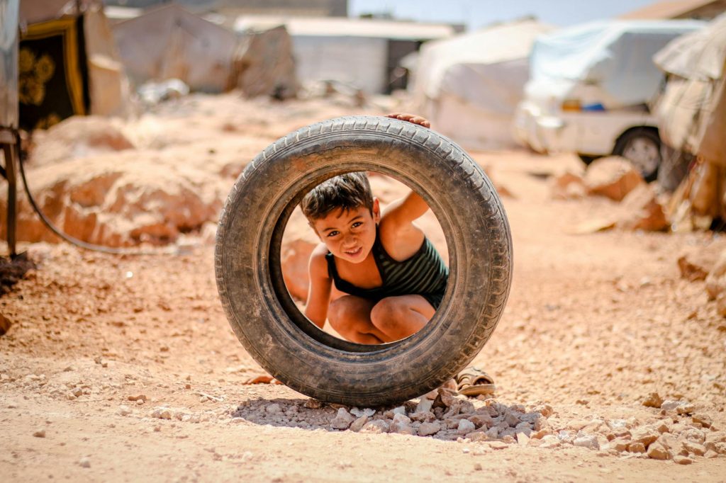 a boy looking through a tire s hole