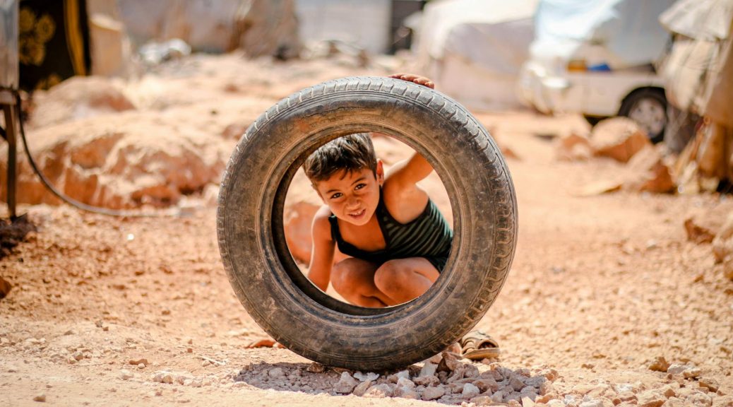 a boy looking through a tire s hole
