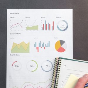 Overhead view of a business desk with charts and a laptop, ideal for data analysis concepts.
